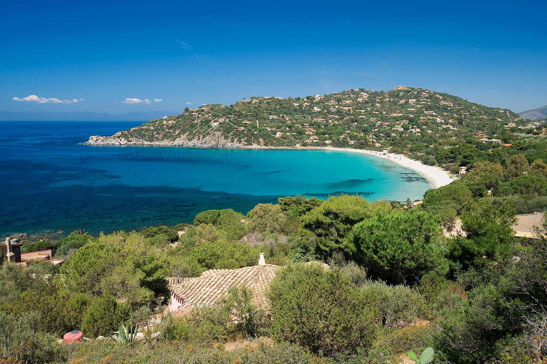 La baia di Genn’e Mari a Torre delle Stelle, con mare turchese, spiaggia e colline verdi